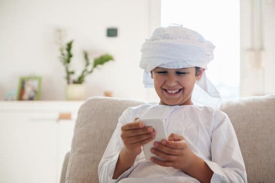 Arab boy using a smartphone at home.