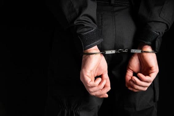 Hands of a criminal in handcuffs.