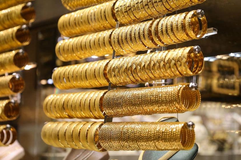 Gold bracelets in a jewelry store window.