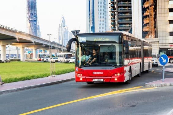 Dubai bus and modern skyscraper along Sheikh Zayed Road.