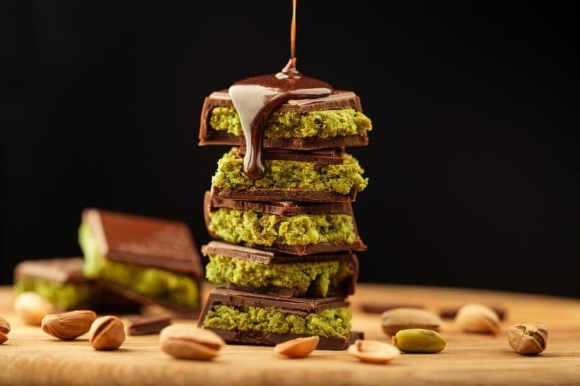Dubai chocolate with pistachios and chocolate drizzled on a table.