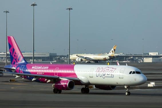 Wizz Air and Etihad planes on Abu Dhabi International Airport runway.