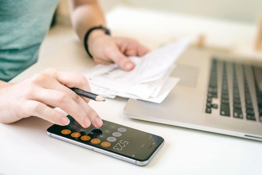 ABU DHABI, Woman managing expenses using a calculator.