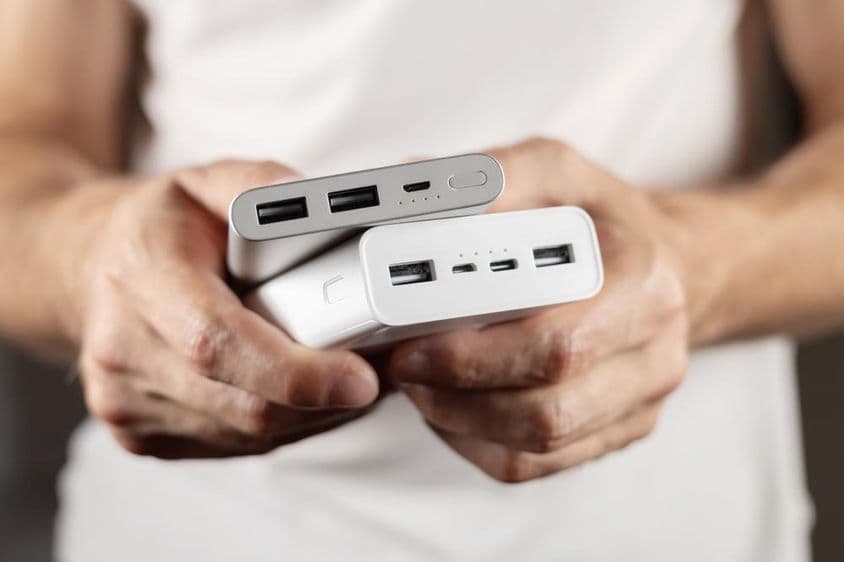 Two external batteries held in hand.