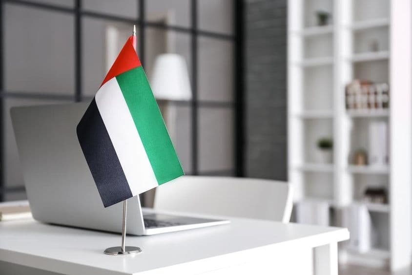 Flag of the United Arab Emirates on a table in a modern office.