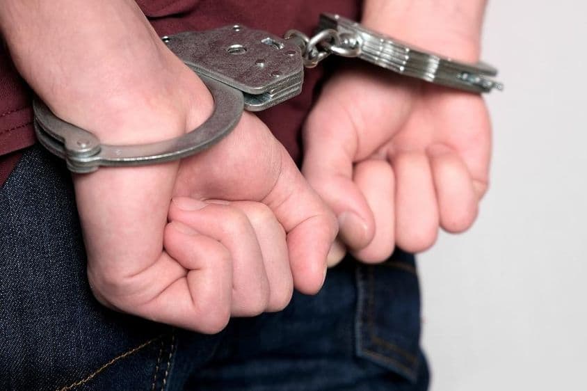 A criminal handcuffed and arrested.