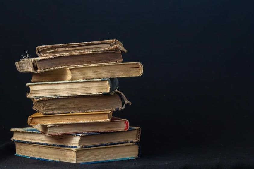 A stack of hardcover old books.