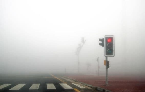 Fog on a Dubai road, red signal flashing.