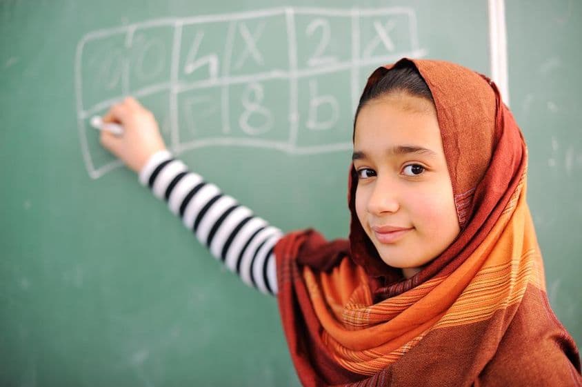 Arab schoolgirl writing on the board.