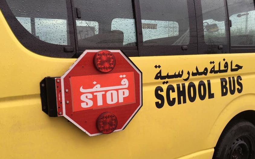 An empty school bus with a red stop warning sign.