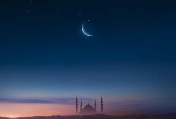 Mosque at sunset with moon in the sky.