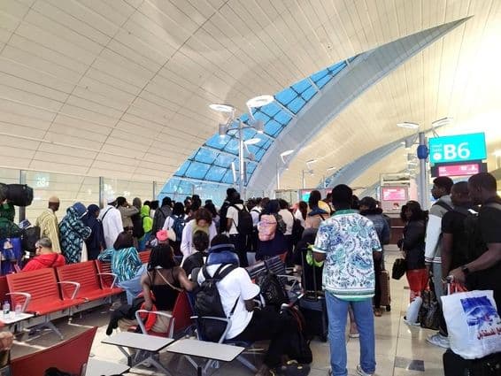 Passengers queue up to board a flight at Dubai International Airport.