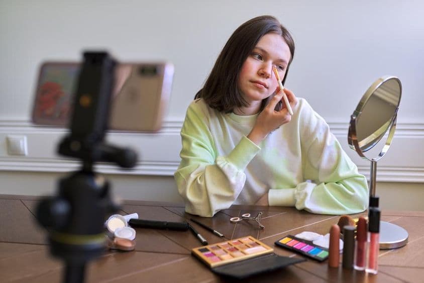 Teenage girl, beauty blogger filming a video for a blog channel.