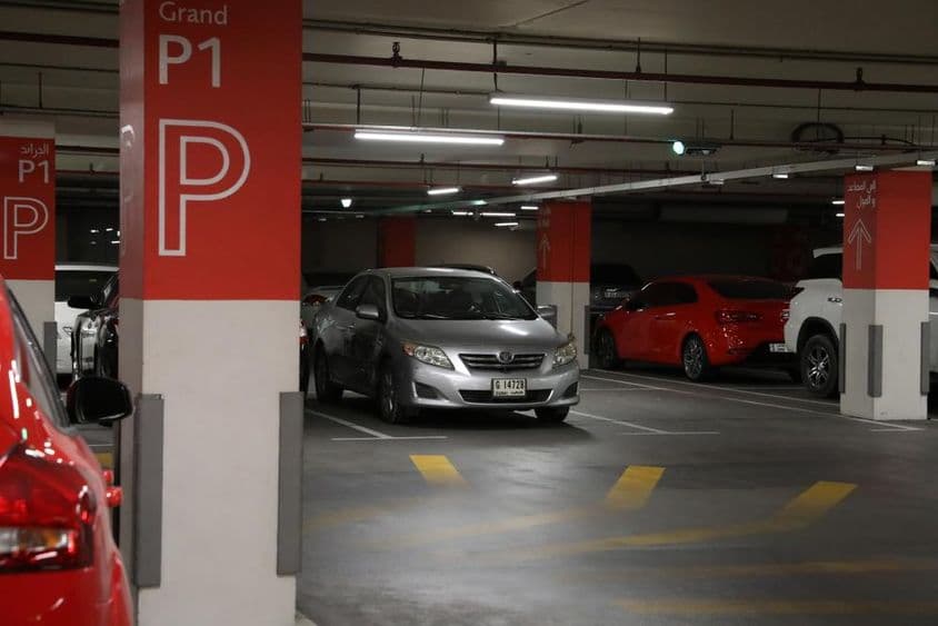 Dubai modern underground parking garage with various cars.