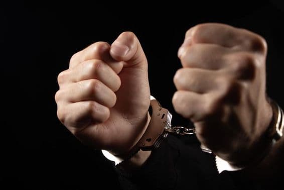 Handcuffed men arrested for crimes.