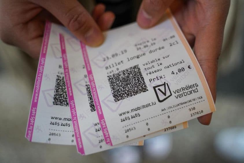 A young man holding tickets in his hand.