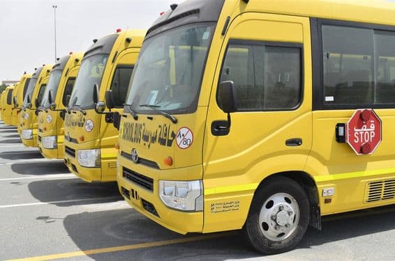 Several yellow school buses lined up in a parking lot in Dubai.