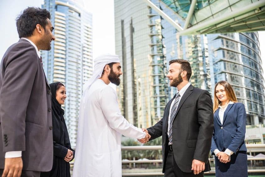 Multinational group of businessmen meeting outdoors in Dubai.