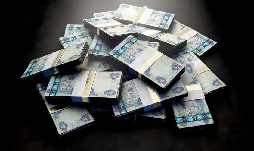 A pile of dirham banknotes scattered randomly.
