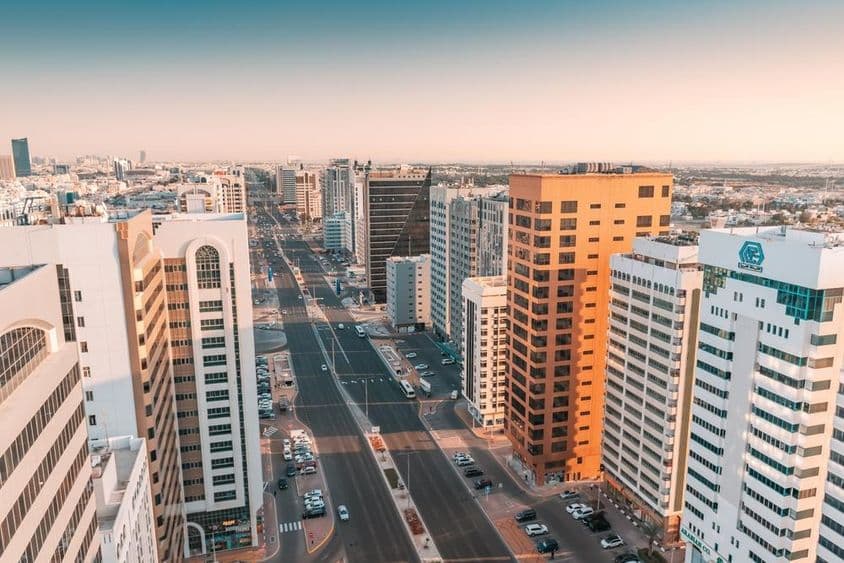 Abu Dhabi, aerial view of a wide street with traffic passing between skyscrapers.