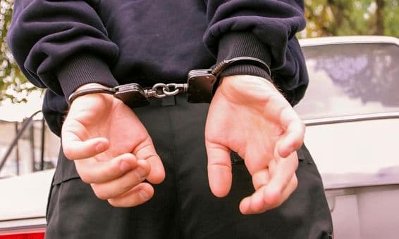 A person with handcuffed hands behind their back.