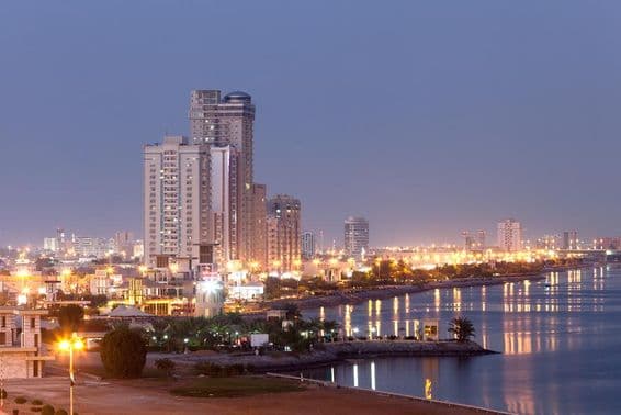 Ras al-Khaimah promenade illuminated at dusk.