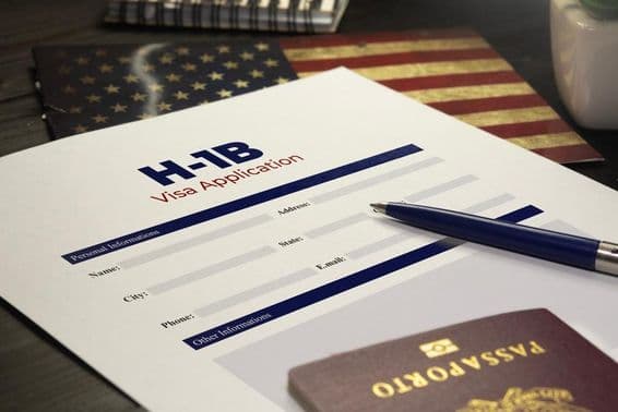 USA H-1B visa application on the table with a passport.