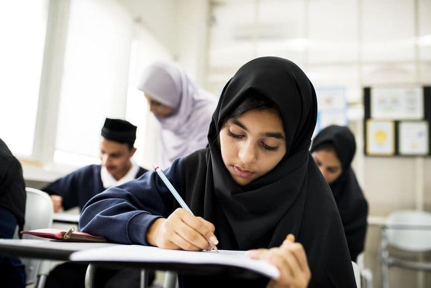 Various Muslim children studying in a classroom.