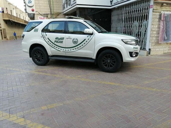 A Dubai police car viewed sideways on a street.