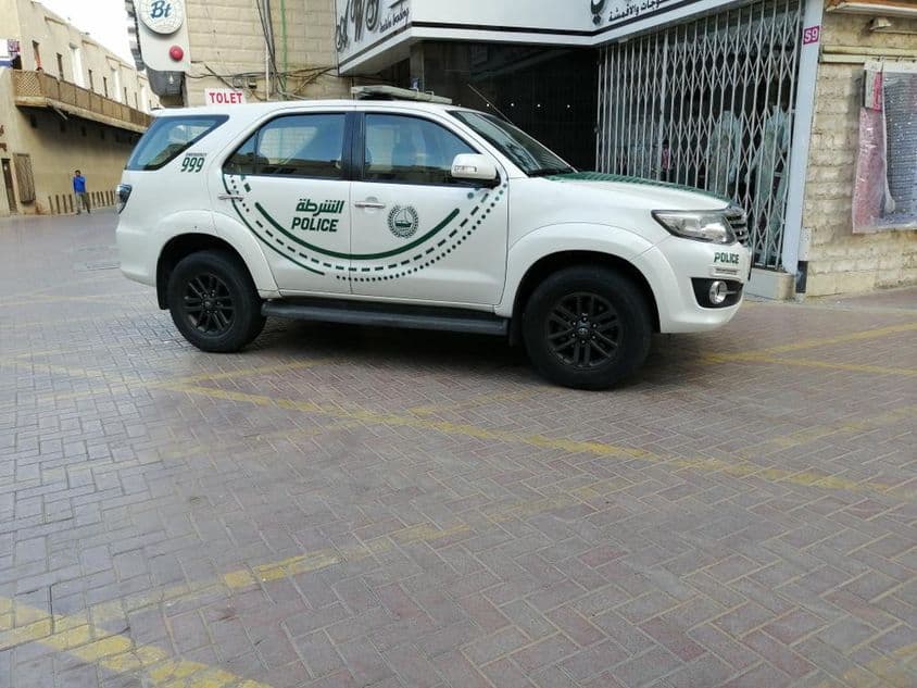A Dubai police car viewed sideways on a street.