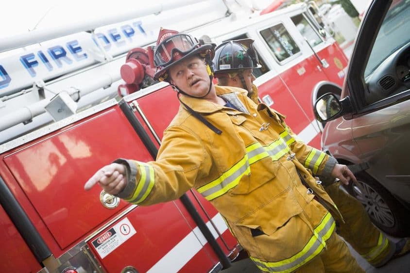 Firefighter in front of a fire truck.