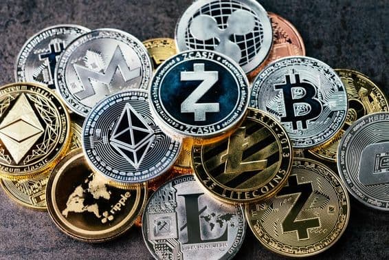 Cryptocurrency symbols in shiny silver and gold physical coins.