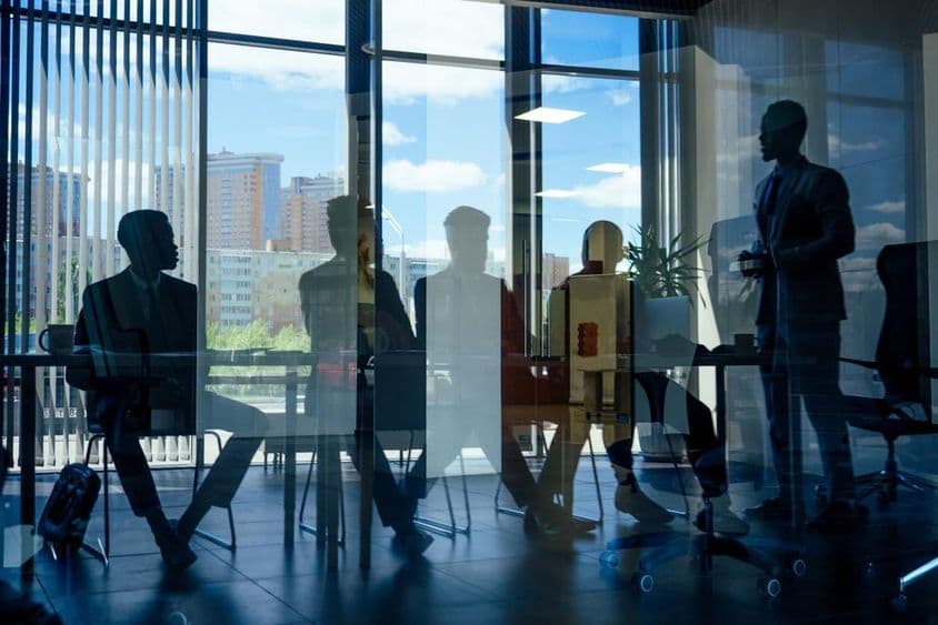 Business executives talking with Arab partners and a colleague.