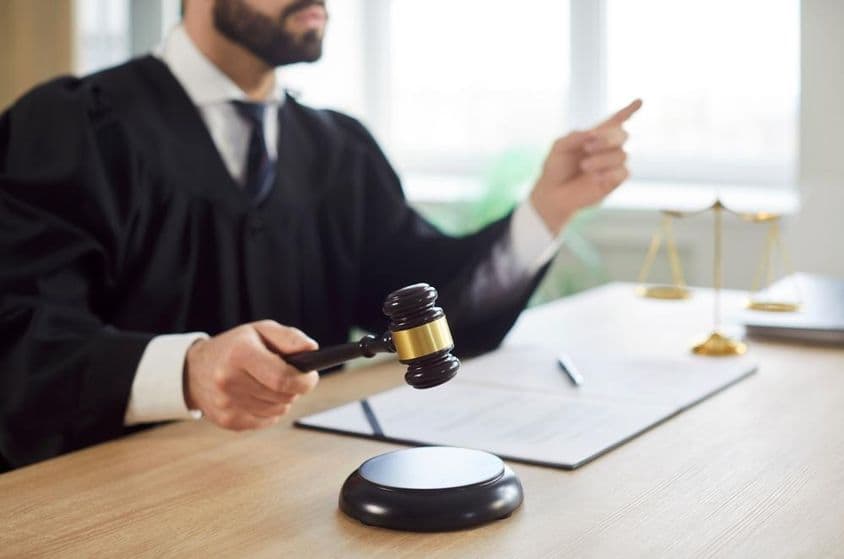 The judge knocks and the court delivers a judgment in the courtroom.