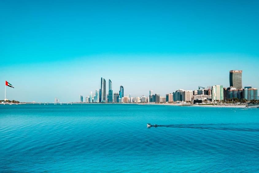 View of Abu Dhabi waterfront with a crossing fishing boat.