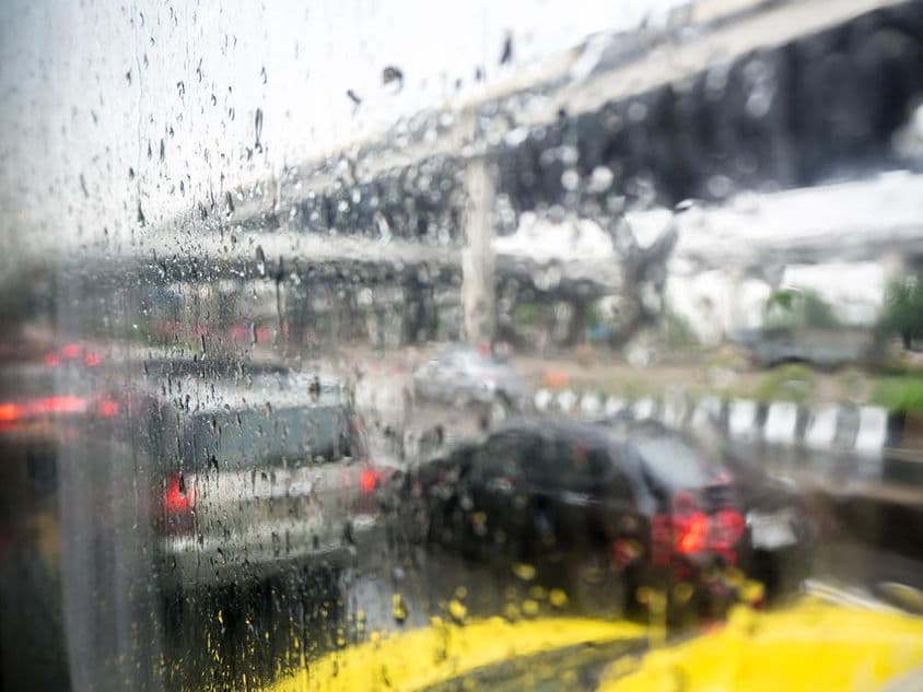 Traffic on a rainy day with raindrops on the car window.