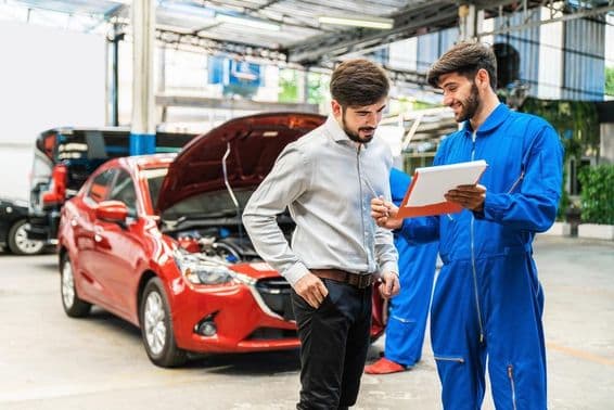 Mechanic showing car inspection checklist to a client.