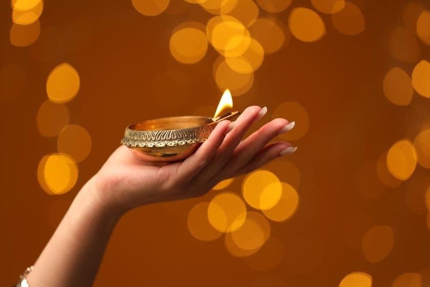 Woman holding a lit Diwali lamp