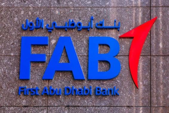 The logo of First Abu Dhabi Bank (FAB) on a bank branch wall.