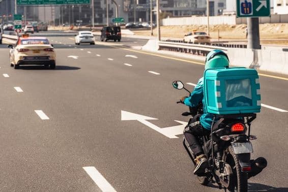 Dubai, man on motorcycle for online food delivery.