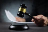 Judge with gavel pronouncing judgment in court.