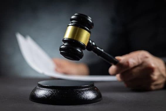 Judge with gavel pronouncing judgment in court.