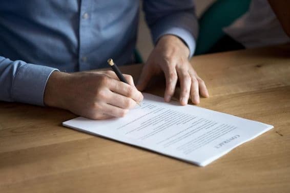 Businessman signing a contract by hand.