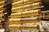 Gold bracelets in a jewelry store display.