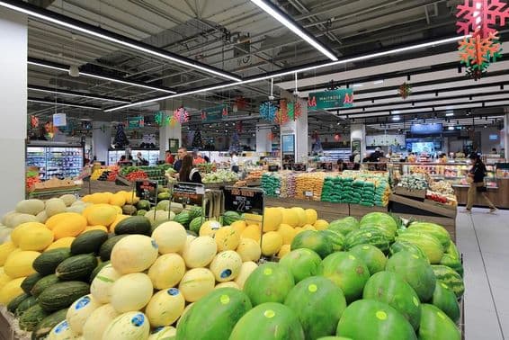 Stacked green and yellow melons for sale to consumers in a Dubai Mall supermarket.