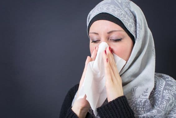 A beautiful Muslim woman with a cold and a runny nose.