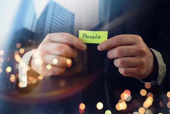 Businessman showing a document with the word 'donation'.