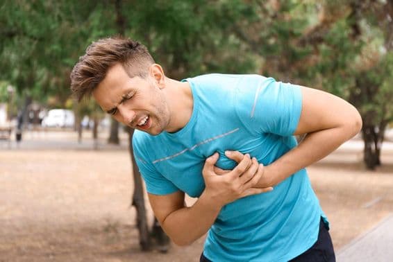 Young man having a heart attack while running in the park.