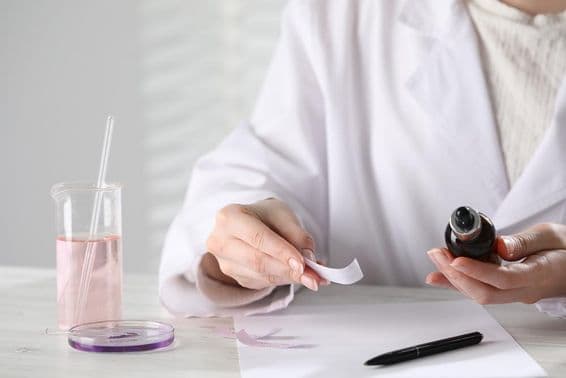 Luxury perfume on a white wooden table in the laboratory.
