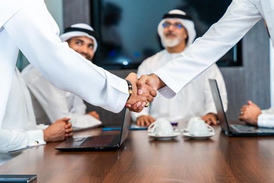 Middle Eastern businessmen in Emirati kandura working in a boardroom in Dubai.